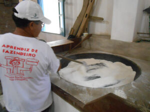 mulher preparando farinha no taxo de cobre