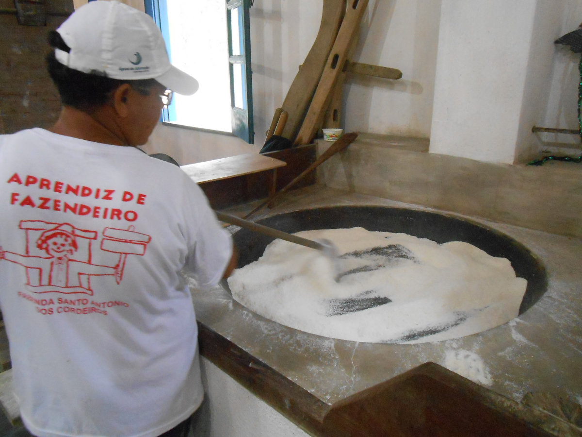 mulher preparando farinha no taxo de cobre